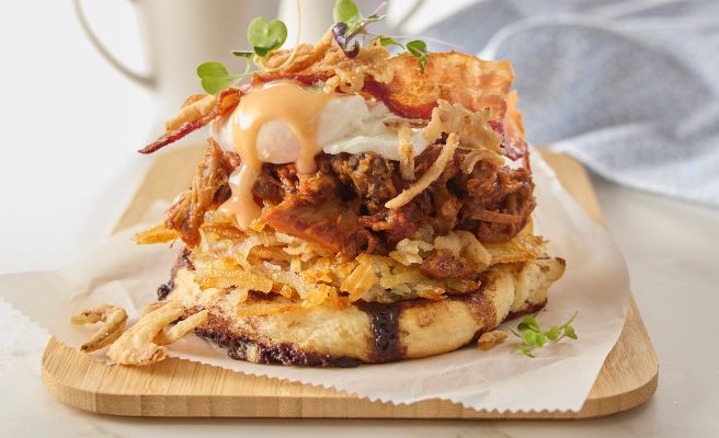 Smashed cinnamon roll sitting on a plate in a diner that specializes in breakfast foods