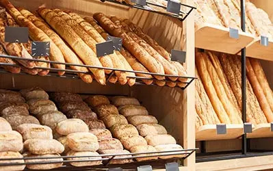 A bakery display featuring an assortment of breads and various baked goods arranged attractively.
