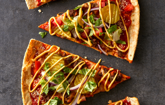 An overhead view of Cheeseburger Pizza slices that feature cracker-like parbaked BONICI® crust.
