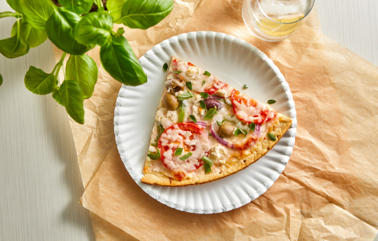 A slice of Greek Pizza, illustrating the variety of toppings you can add to a BONICI® parbaked crust.